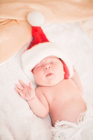 Infant boy in Santa hat laying on the bedの写真素材