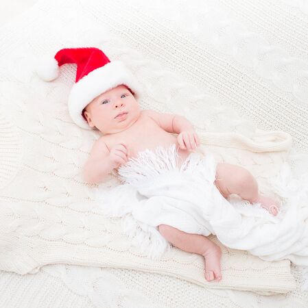Infant boy in Santa hat laying on the bedの写真素材