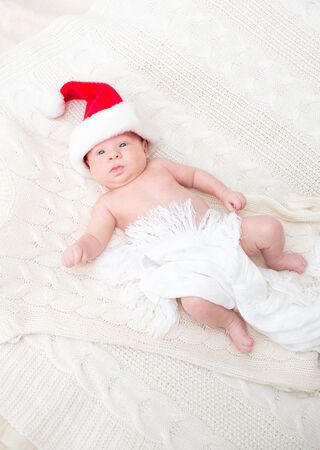 Infant boy in Santa hat laying on the bedの写真素材