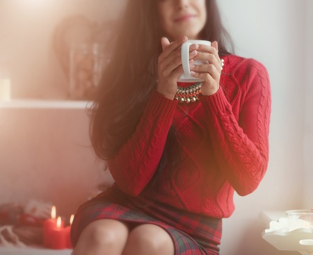 Young beautiful woman drinking coffe at homeの写真素材