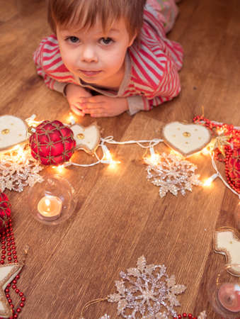 Little boy laying on the floor with christmas decorationsの写真素材