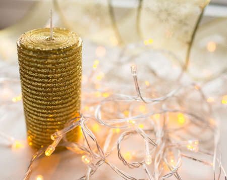 Decoration xmas gold color ribbon with garland lights on backgroundの写真素材