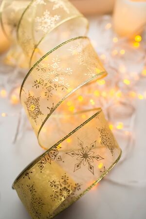 Decoration xmas gold color ribbon with garland lights on backgroundの写真素材
