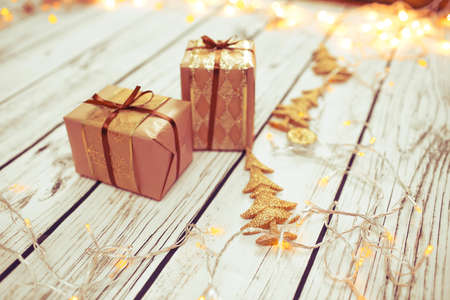 Christmas presents in golden boxes on wooden floor in vintage styleの写真素材