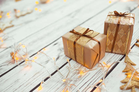Christmas presents in golden boxes on wooden floor in vintage styleの写真素材