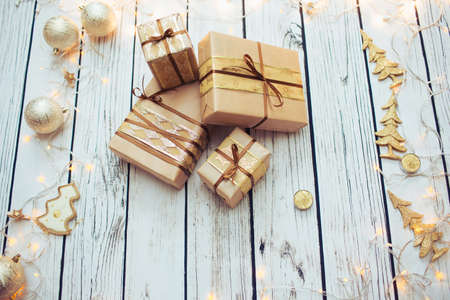 Christmas presents in golden boxes on wooden floor in vintage styleの写真素材