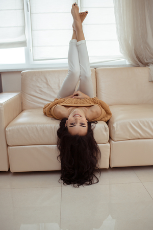 Young beautiful woman in sweater at homeの写真素材