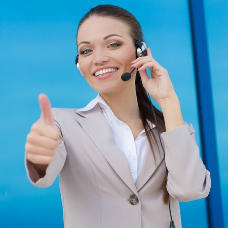 Portrait of happy smiling female customer support phone operatorの写真素材
