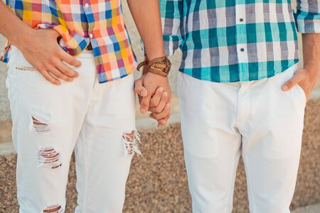 Two boyfriends in summer clothes holding hands