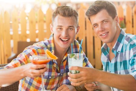 Two men drinking coctails in summer caffeの写真素材