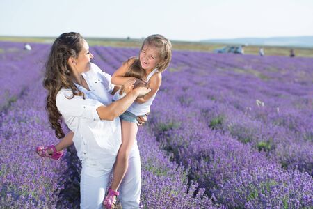 Beautiful happy couple mother and her  cute daughter  in lavender fieldの写真素材