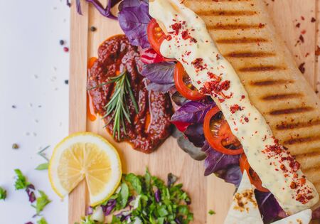 Long Ciabatta Sandwich with lettuce, slices of fresh tomatoes, cucumber, basilic and salamiの写真素材
