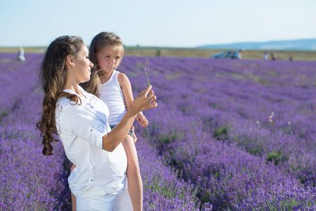 Beautiful happy couple mother and her  cute daughter  in lavender fieldの写真素材