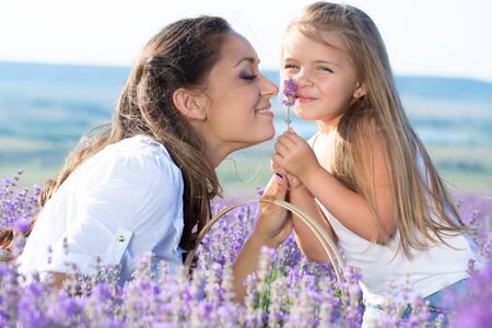 Beautiful happy couple mother and her  cute daughter  in lavender fieldの写真素材