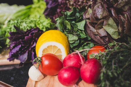 Fresh green lettuce and vegetables on wooden cutting boardの写真素材