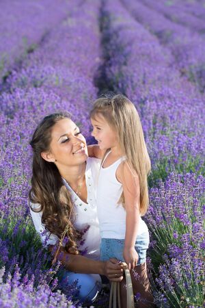 Beautiful happy couple mother and her  cute daughter  in lavender fieldの写真素材