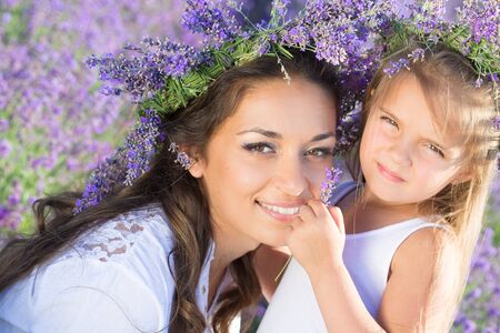 Beautiful happy couple mother and her  cute daughter  in lavender fieldの写真素材
