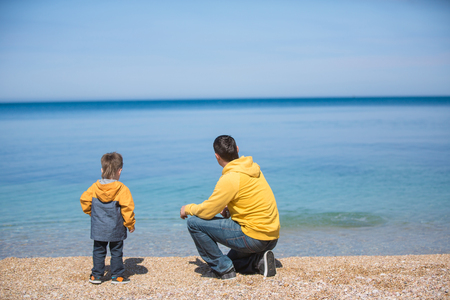 Father and son playing on the beach at the day time. Concept of friendly family.の写真素材