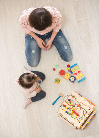 Mother and daughter indoors playing wooden toysの写真素材
