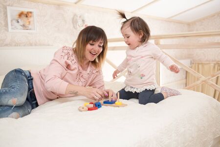 Mother and daughter indoors playing wooden toysの写真素材