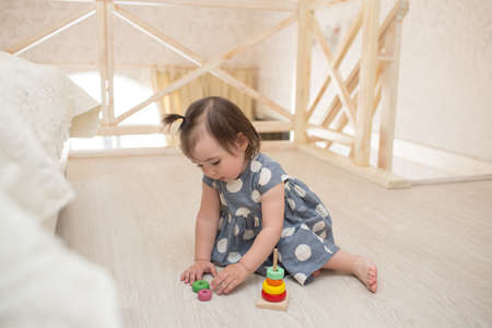 Little cute toddler girl  indoors playing wooden toysの写真素材
