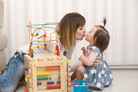 Mother and daughter indoors playing wooden toysの写真素材