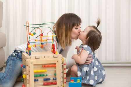 Mother and daughter indoors playing wooden toysの写真素材