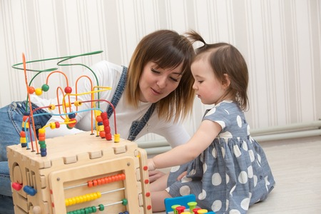 Mother and daughter indoors playing wooden toysの写真素材