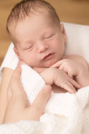 Healthy newborn baby sleeping on white sheetの写真素材
