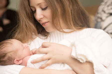 Cute infant on the hands of mother