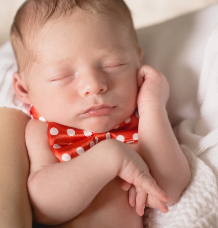 Healthy newborn baby sleeping on white sheetの写真素材