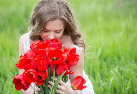 Young woman with red tulip flowers bouquetの写真素材