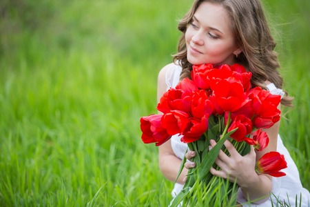 Young woman with red tulip flowers bouquetの写真素材