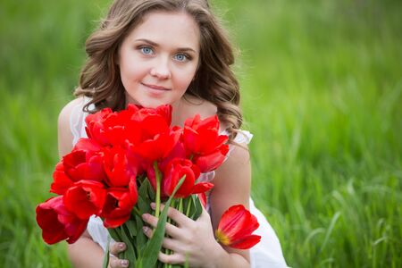 Young woman with red tulip flowers bouquetの写真素材