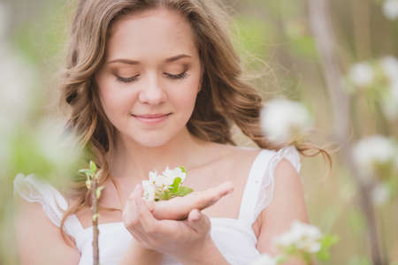 Young beautiful woman near blossom apple treeの写真素材
