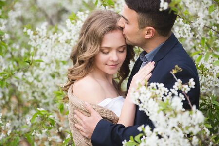 Young couple in love near the blossom apple treeの写真素材