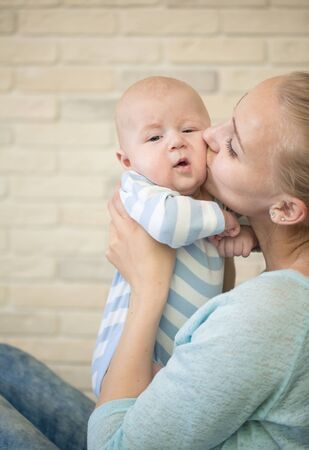 Portrait of happy young mother and baby at homeの写真素材