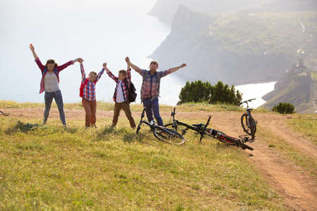 Family of four people with bikes in the mountainsの写真素材