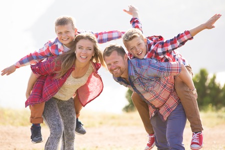 Family of four people looking to beautiful seascape in mountainsの写真素材
