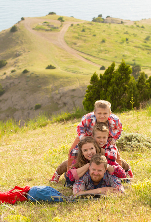 Family of four people looking to beautiful seascape in mountainsの写真素材