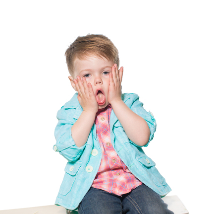 Cheerful little boy play the ape in studio. Isolated on white background.の写真素材