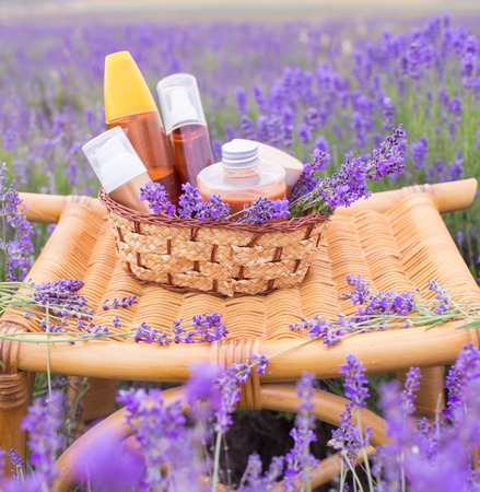 Herbal soaps with flowers and group of lotions in bottles on lavender field backgroundの写真素材
