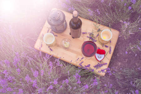 Small table with bottle of wine decorated for engagement in lavender field.の写真素材