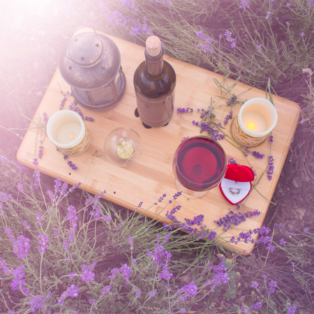 Small table with bottle of wine decorated for engagement in lavender field.の写真素材