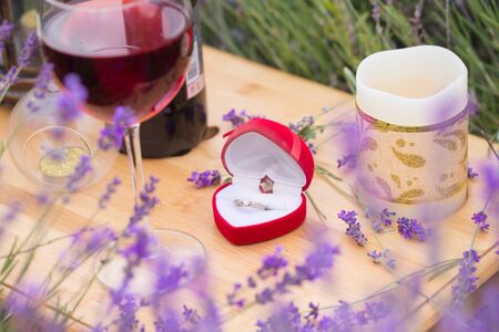 Small table with bottle of wine decorated for engagement in lavender field.