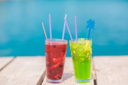 Two glasses of mojito coctail on wood table with blue sea backgroundの写真素材