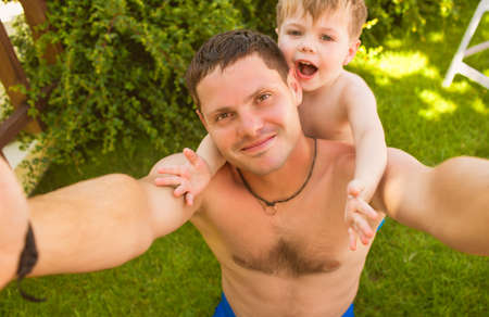 Father and son making selfie on the grass and smilingの写真素材