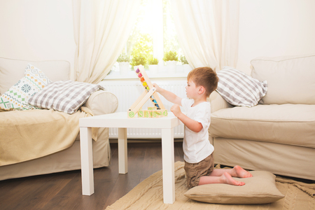 Little boy playing with abacus toy at homeの写真素材
