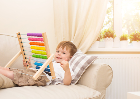 Little boy playing with abacus toy at homeの写真素材