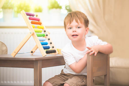 Little boy playing with abacus toy at homeの写真素材